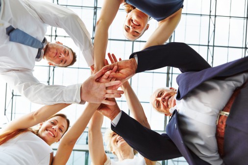 Cooperation and teamwork in business team with many hands stacked on a pile